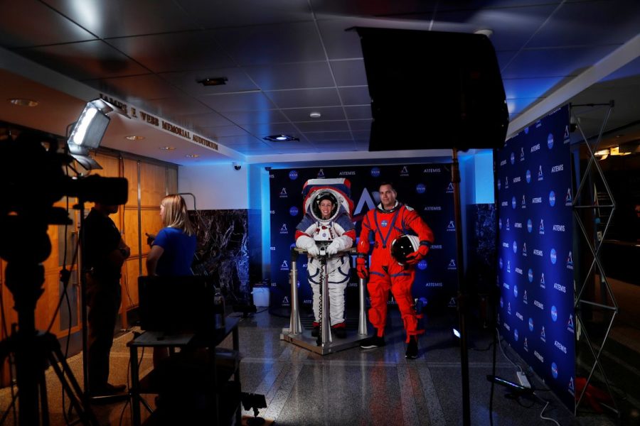 Advanced Space Suit Engineer at NASA Kristine Davis wears the xEMU space suit next to lead engineer Dustin Gohmert wearing the Orion crew survival spacesuit prototype for the next astronaut to the moon by 2024, during a presentation at NASA headquarters in Washington, U.S., October 15, 2019. REUTERS/Carlos Jasso